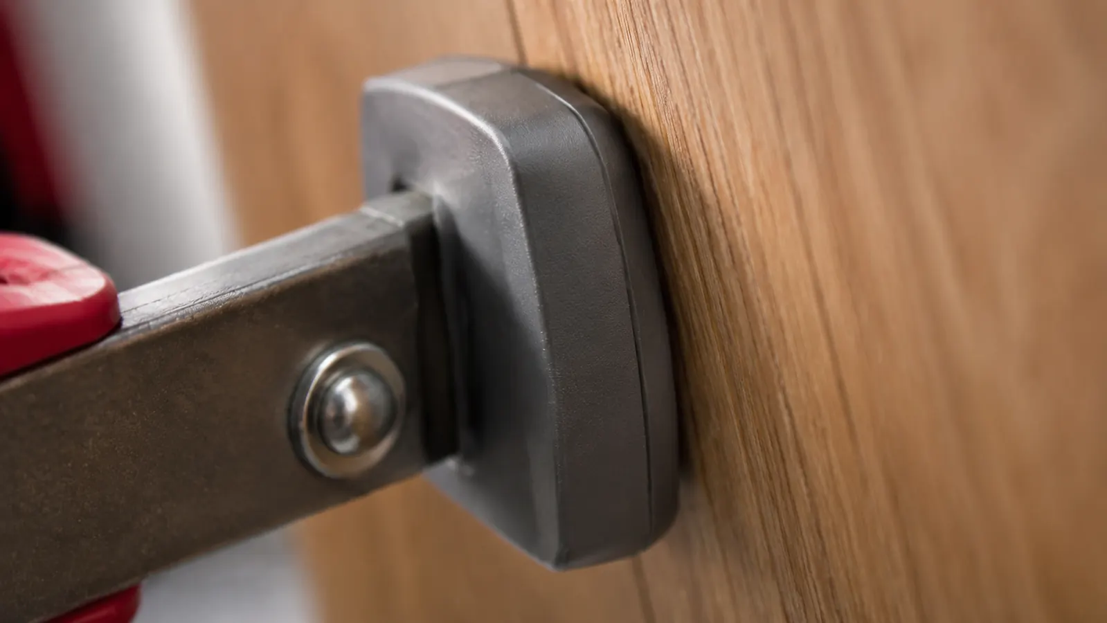 Close-up of the rubber non-marring jaw pads on an IRWIN Quick-Grip clamp pressed against a finished oak board