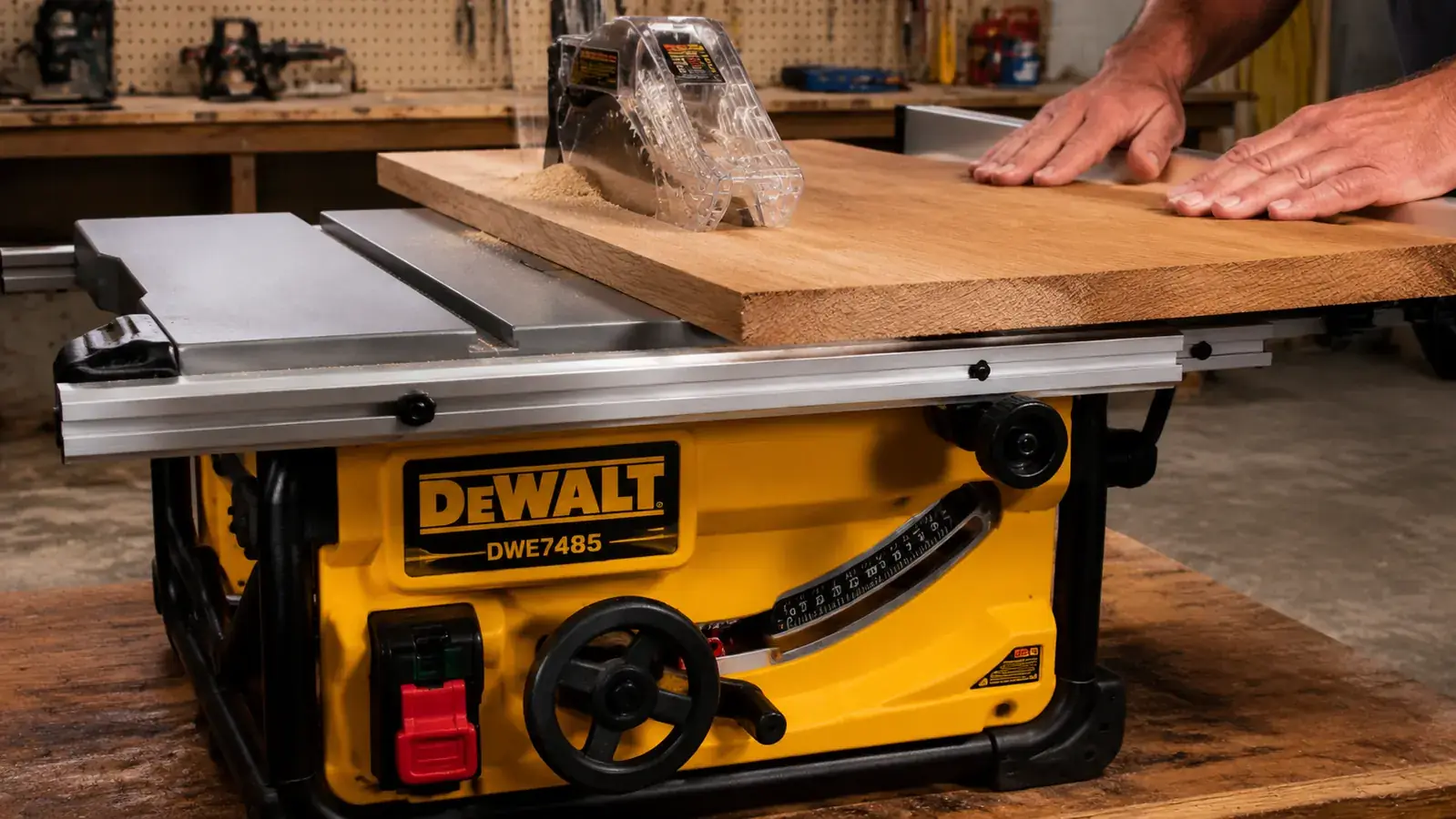 Hand guiding a piece of oak through the DeWalt DWE7485 fence for a rip cut