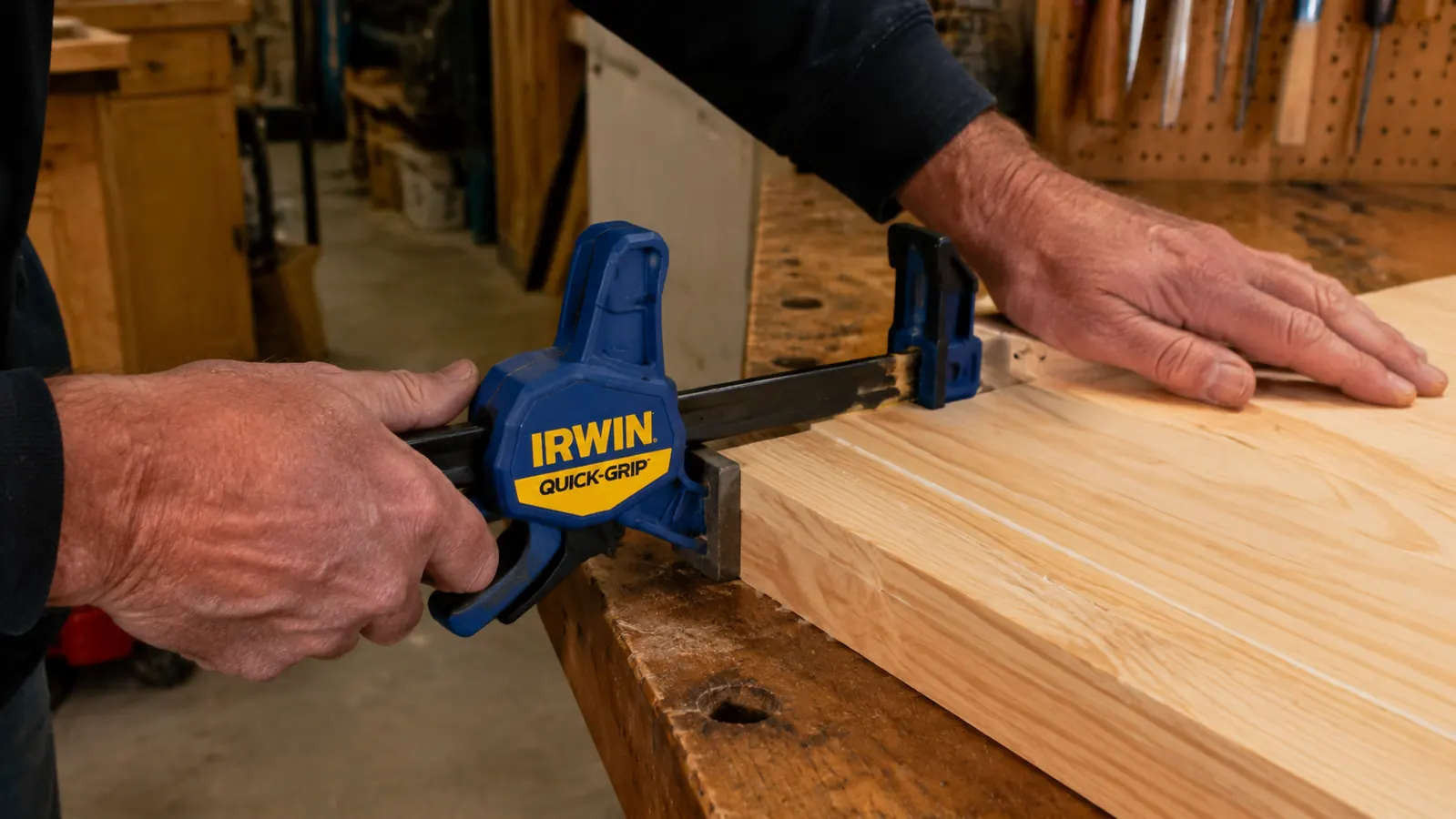 One-handed IRWIN Quick-Grip clamp holding a glue-up panel while the woodworker positions a second board